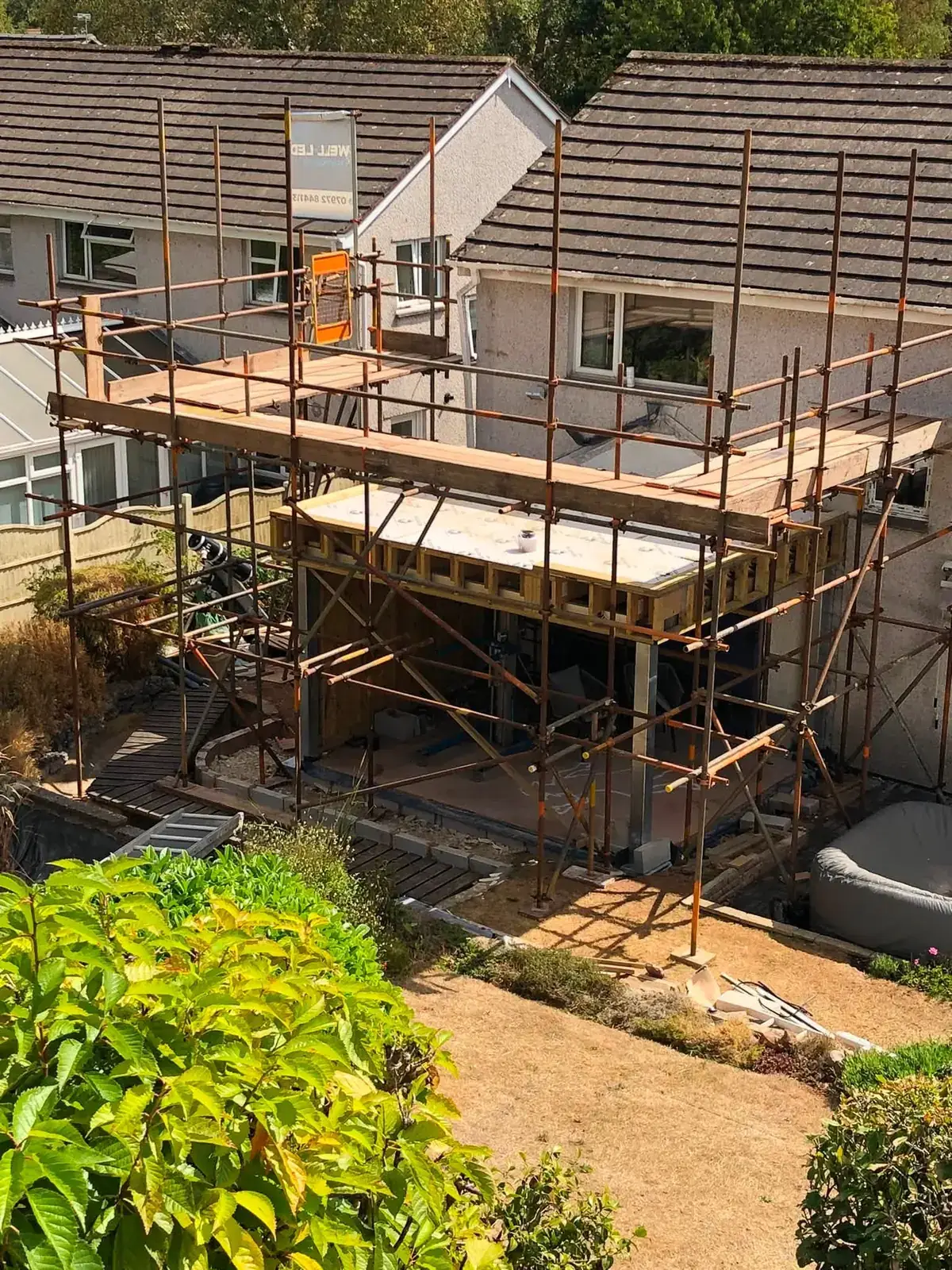 Scaffolding to a rear extension and flat roof at the back of a house in Exeter, Devon.
