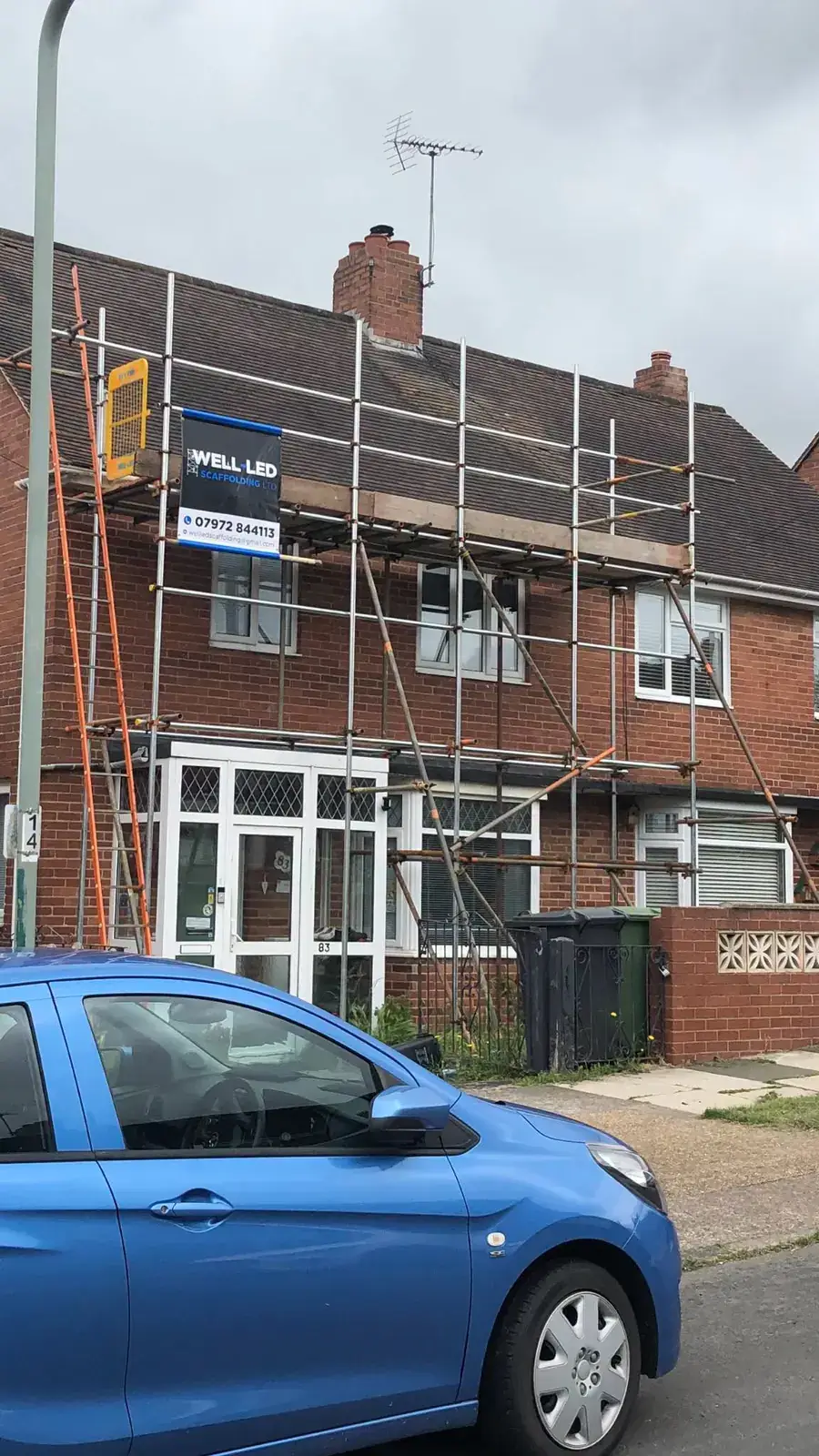 Roof scaffold spanning a red-brick semi-detached house in Exeter, Devon.