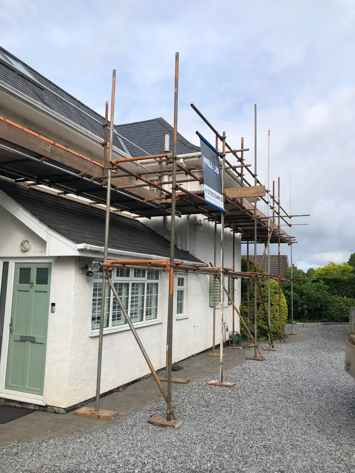Single-lift roof scaffold along the front of a white rendered bungalow in Exeter.