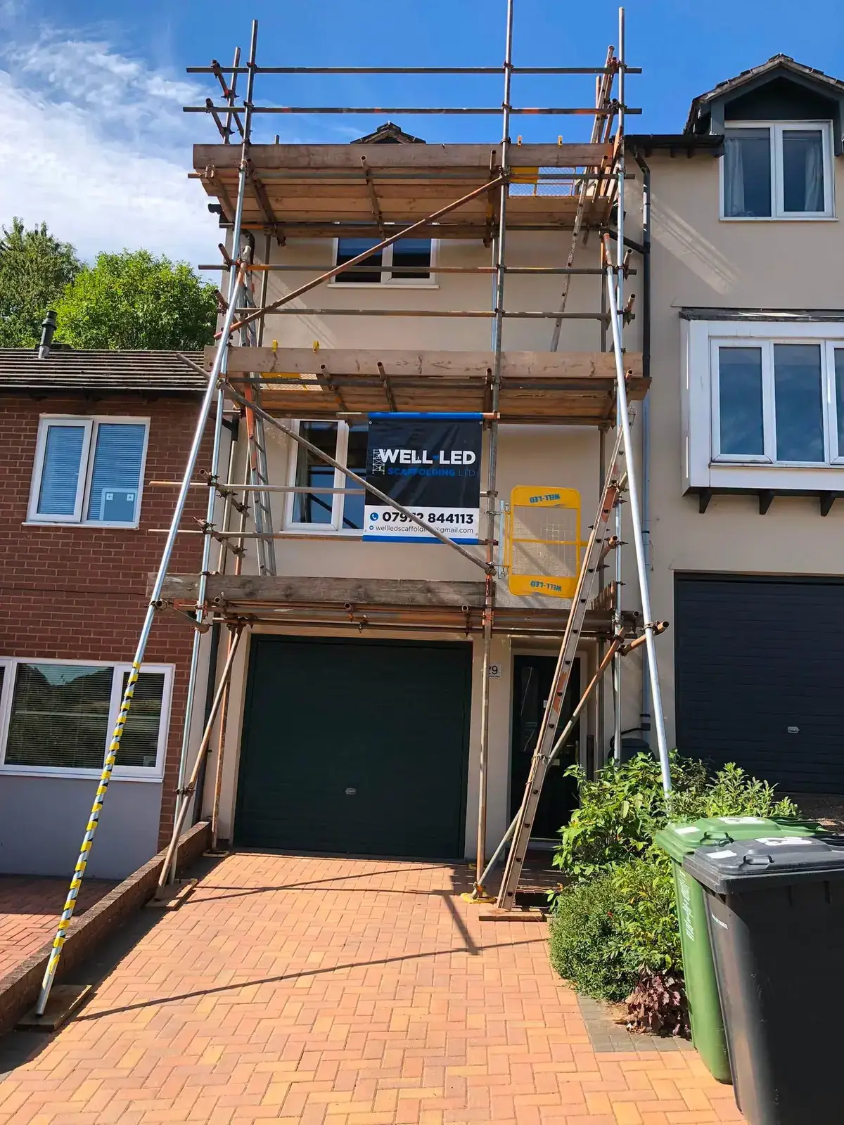 Three-storey townhouse in Exeter with a full scaffold up the front elevation for roof works.